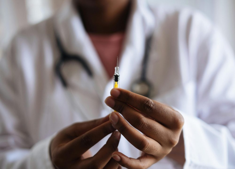 Close-up of a healthcare professional holding a syringe, symbolizing medical care and vaccination.