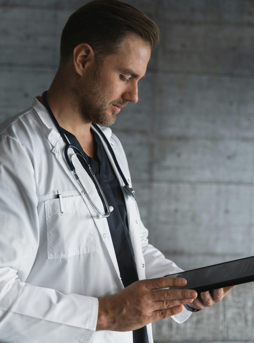 Portrait of a confident male doctor using a tablet indoors.